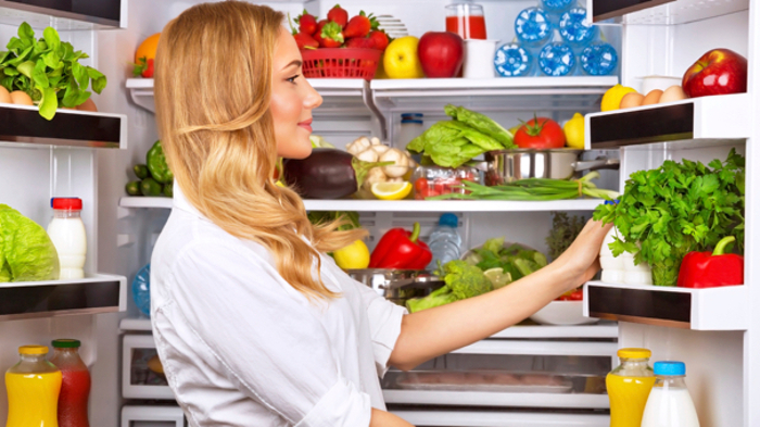 Žena uzima namirnice iz frižidera